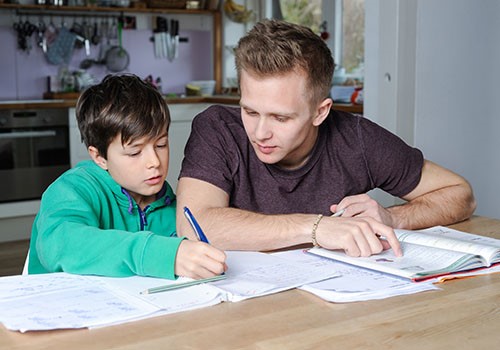 A young adult tutoring a small child.