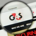 A magnifying glass enlarging the G4S logo on the company website.
