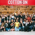 A group employee picture outside a Cotton On store.