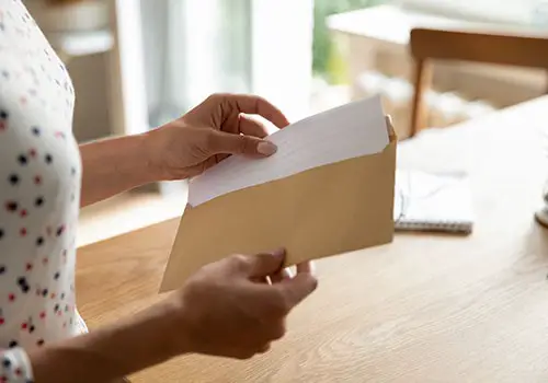 A person opening a letter