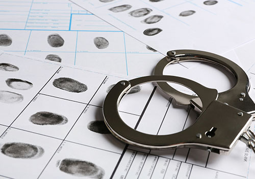 set-of-handcuffs-on-top-of-fingerprint-record-sheets